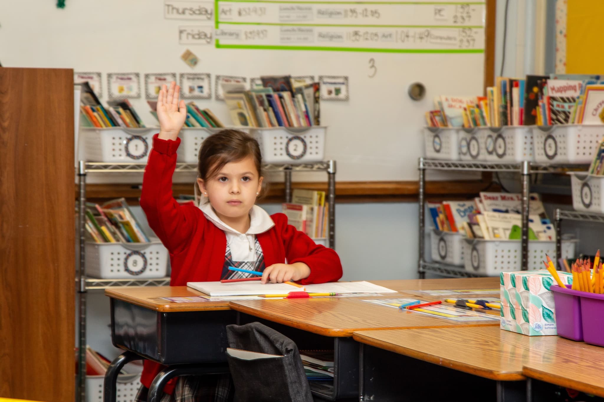 A first grade student asks a question during a spelling lesson